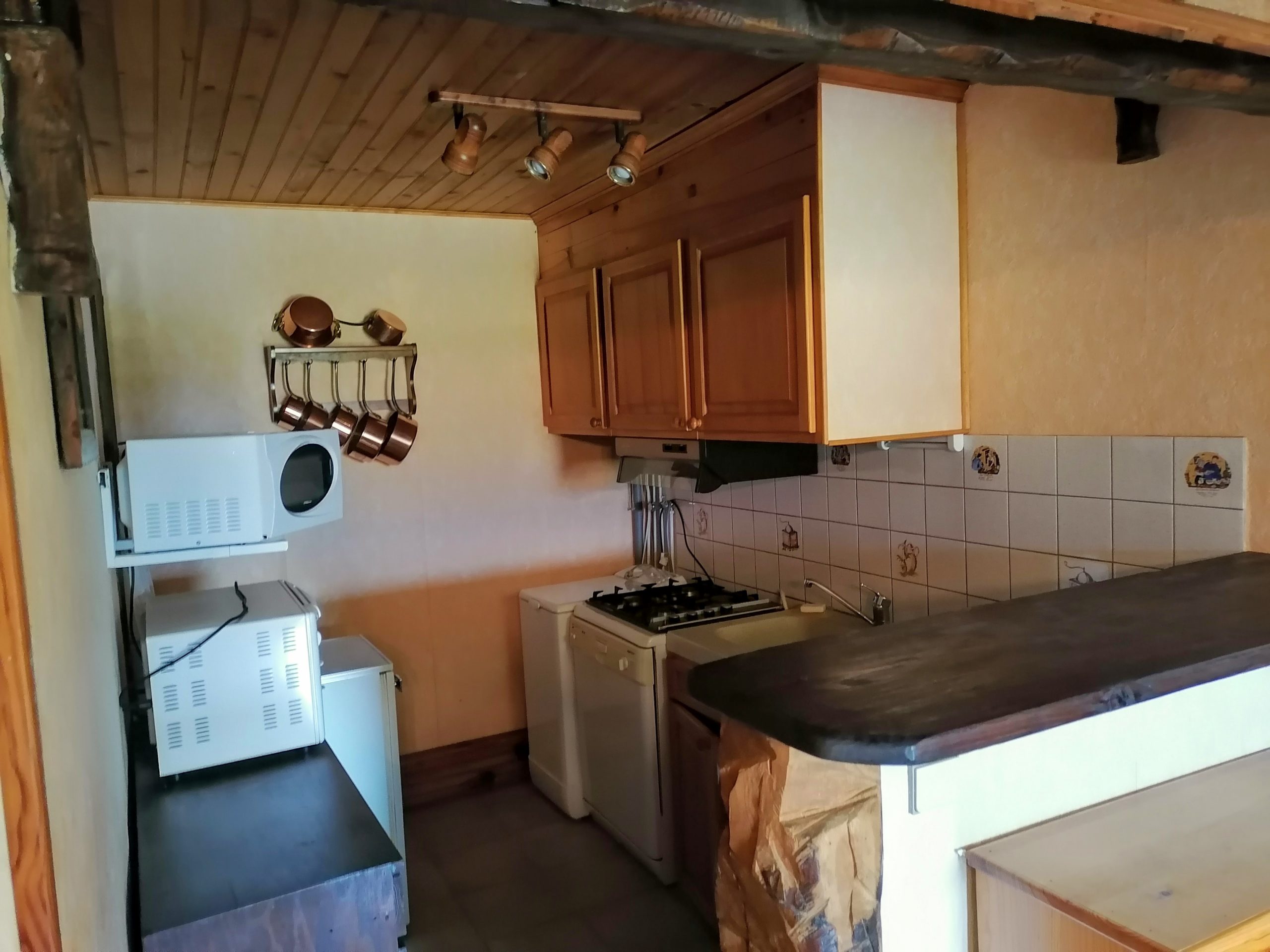 Cuisine avant rénovation — lambris foncé et bar séparateur, Atelier Roudoune