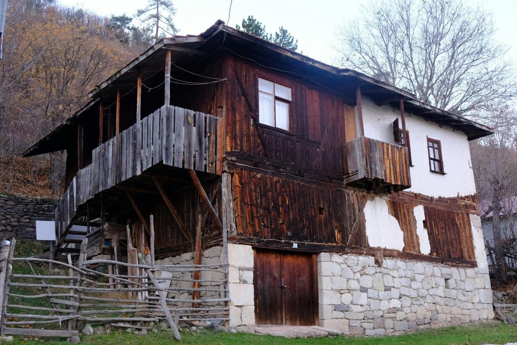 Vieux chalet avec soubassement en pierre et bardage en bois abimé